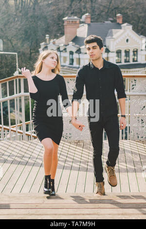 Beau jeune couple multiracial, un couple d'étudiants à pied sur l'escalier à Kiev, dans le centre-ville. Belle brunette turc guy hugging, holding Banque D'Images