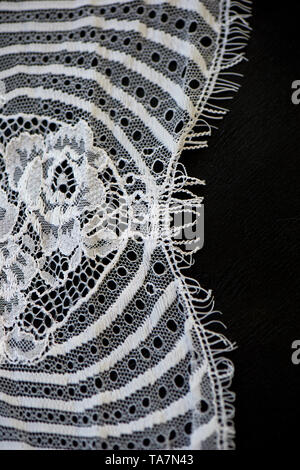 Dentelle blanche sur fond noir. La texture est proche. Banque D'Images