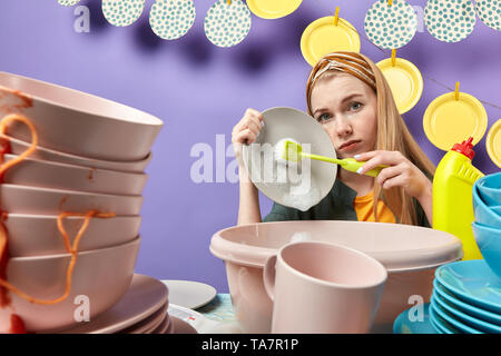 Triste Malheureux jeune femme sérieuse à l'aide de brosse des travaux ménagers dans la profession, d'emploi possèdent, l'occupation concept. close up portrait Banque D'Images