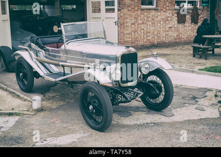 1923 Alvis voiture en face d'un garage à Bicester Heritage Centre 'Drive il Day'. Bicester, Oxfordshire, Angleterre. Vintage filtre appliqué Banque D'Images