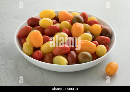 La plaque avec un mélange de petites tomates mûres colorés Banque D'Images