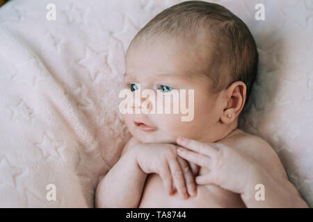 Cute adorable bébé nouveau-né fille dans un lit et enveloppé dans une couverture rose. Nouveau-né, petite fille à la surprise de l'appareil photo. Famille, vie nouvelle, Banque D'Images