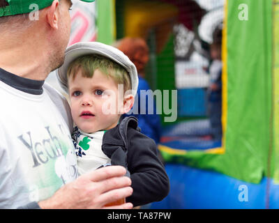 Petit garçon est tenu par son père au jour de la Saint Patrick 2019 Block Party à Corpus Christi, Texas USA. Banque D'Images