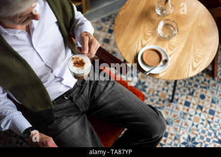 Senior ayant une tasse de café au bar Banque D'Images