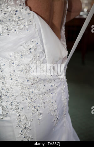 Robe de mariage se fait avant elle se marie, Lacey brides robe lacée par sa mère, pas de visages, pas de gens,au lieu de mariage dans Bromsgrove Banque D'Images