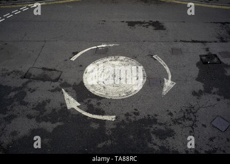 Une vue aérienne d'une route peint flèche rond-point avec pas de voitures sur pourrait être utilisé pour analogie ou la notion de droit d'être confus ou perdus etc. Banque D'Images