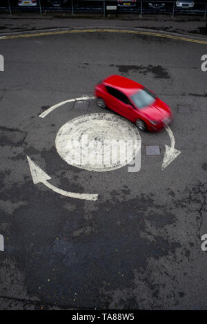 Vue aérienne d'une flèche peinte rond-point avec une seule voiture. Pourrait être utilisé comme une analogie ou un concept comme perdu ou à tourner en rond. Banque D'Images
