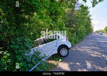 Une berline blanche face vers le bas dans un fossé après avoir perdu sur une route principale, Shepperton Surrey England UK Banque D'Images