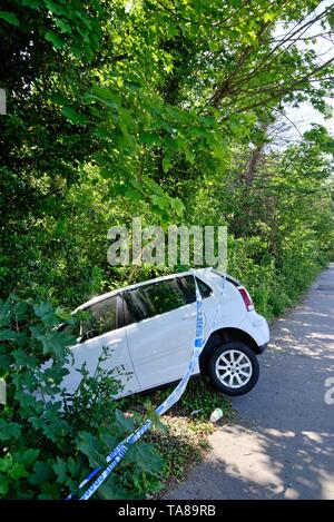 Une berline blanche face vers le bas dans un fossé après avoir perdu sur une route principale, Shepperton Surrey England UK Banque D'Images
