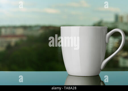 Mug blanc vierge sur rebord de la piscine Banque D'Images