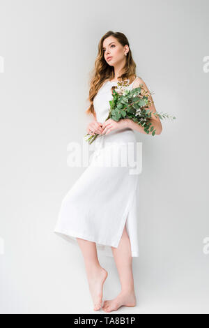 Woman in dress holding bouquet de chrysanthèmes et chamelaucium avec des feuilles d'eucalyptus on white Banque D'Images