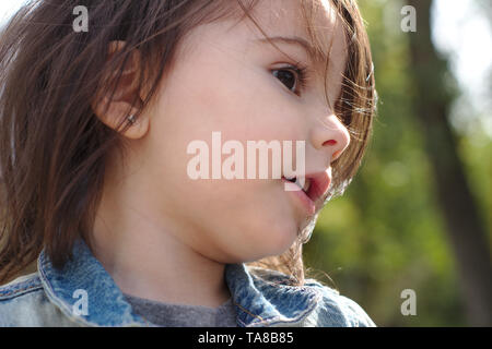 Closeup portrait of cute little Girl with pigtails émotionnelle dans une veste en jean Banque D'Images