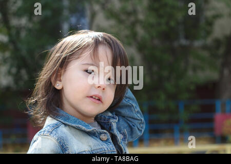 Closeup portrait of cute little Girl with pigtails émotionnelle dans une veste en jean Banque D'Images