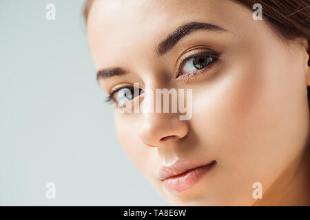 Jolie jeune femme aux lèvres luisantes et Golden Eye shadow isolé sur gray Banque D'Images