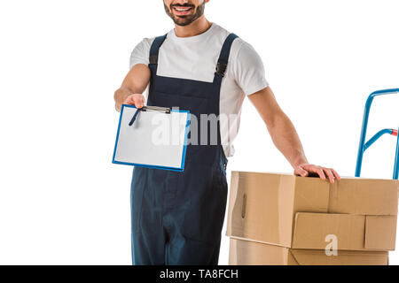 Portrait de l'homme livraison debout près de boîtes en carton et de papier vierge avec presse-papiers holding isolated on white Banque D'Images