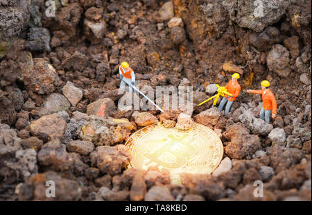 Or l'exploitation minière Travailleur Figurines Bitcoins sur creusant profond du sol / virtual concept cryptocurrency minière bitcoin - selective focus Banque D'Images