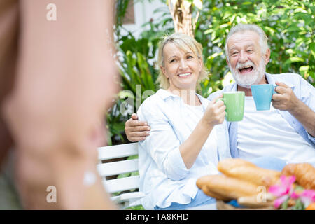 Des moments heureux. L'âge de la retraite joyeuse gentil couple prenant le thé et de rire tout en profitant de leur temps ensemble - Image Banque D'Images