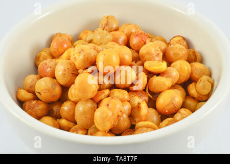 Le sel dans la tasse de haricots rôti croustillant de pois chiches isolé / jaune - Snack boulangerie bean cook avec assaisonnement de sel - maïs géant, isolé sur fond blanc Banque D'Images