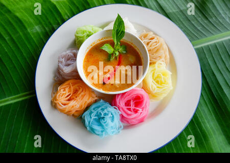 Nouilles de riz thaï ou colorées des vermicelles de riz et nouilles et Sauce soupe curry de poisson avec légumes sur la plaque la feuille de banane contexte / Thai style alimentaire delicio Banque D'Images