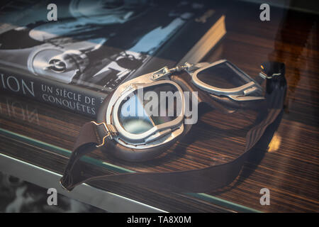 Genève, Suisse, 03 mars 2019 course en cuir vintage des lunettes. Lunettes aviateur pilote sur l'affichage pour la vente, l'Aviation livre en arrière-plan Banque D'Images