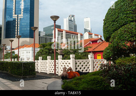 17.05.2019, Singapour, République de Singapour, en Asie - Un homme se repose dans le quartier chinois avec le quartier central des affaires en toile de fond. Banque D'Images