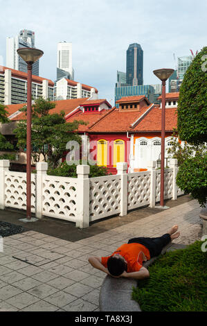 17.05.2019, Singapour, République de Singapour, en Asie - Un homme se repose dans le quartier chinois avec le quartier central des affaires en toile de fond. Banque D'Images