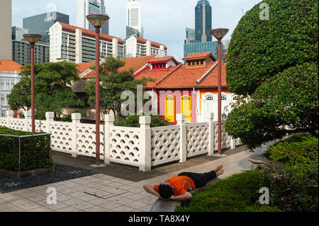 17.05.2019, Singapour, République de Singapour, en Asie - Un homme se repose dans le quartier chinois avec le quartier central des affaires en toile de fond. Banque D'Images