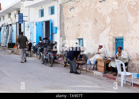 SOUSSE, Tunisie, Afrique-vers mai, 2012 : les habitants d'une petite ville s'asseoir le long des murs des maisons à midi. Ruelles de Sousse ville avec everyd Banque D'Images