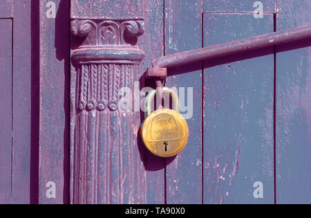 Cadenas en laiton verrouillage d'une porte ou un portail en bois violette Banque D'Images