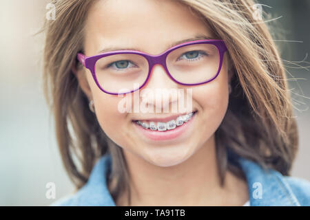 Portrait of happy young girl avec appareil dentaire et lunettes. Banque D'Images