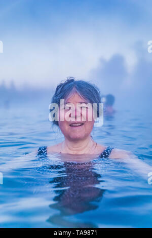 Karen Rentz trempage dans le Secret Lagoon, une des sources chaudes naturelles dans la région de Fludir, Islande Banque D'Images