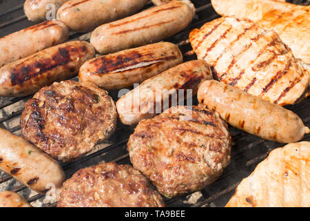Sélection de saucisses de porc, hamburgers de bœuf et filets de poulet grillés par temps chaud en mai. Lancashire Angleterre GB Banque D'Images