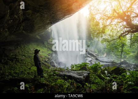 Jungle belle cascade Mountain river stream - cascade paysage avant de la grotte avec l'homme trekking dans la forêt verte nature plante arbre rainfores Banque D'Images