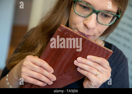 Iphofen, Allemagne. 21 mai, 2019. Julia, un employé du Musée de Knauf, démontre la fonctionnalité d'une grande flûte de pan fait d'argile tirée à partir de Lima, Pérou (ca. 18 après J.-C.) pendant les travaux de construction pour l'exposition "sons de la vieille Amérique Latine - Instruments de musique dans l'art et la culture". À partir du 26 mai, le musée sera montrant autour de 40 instruments de musique anciens de l'Amérique centrale et du Sud. Selon le musée, les instruments seront au public pour la première fois. Les plus âgés ont plus de 4000 ans, le plus jeune d'environ 1400 ans. Crédit : Daniel Karmann/dpa/Alamy Live News Banque D'Images