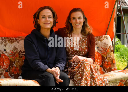 Lehrte, Allemagne. 23 mai, 2019. Claudia Michelsen (l), actrice, et Karin Hanczewski, actrice, Hollywood s'asseoir sur une balançoire dans un décor de film pour un drame familial NDR avec le titre de travail "Auf dem Grund'. Credit : Christophe Gateau/dpa/Alamy Live News Banque D'Images