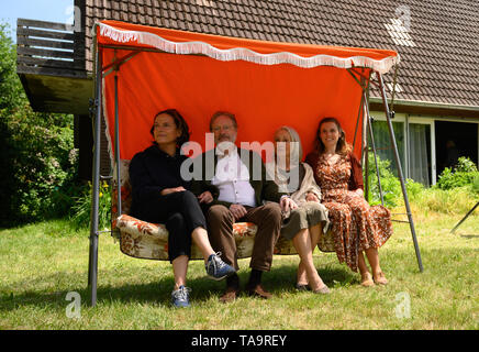 Lehrte, Allemagne. 23 mai, 2019. Claudia Michelsen (l-r), l'actrice, Michael Wittenborn, acteur, Eleonore Weisgerber, actrice, et Karin Hanczewski, actrice, Hollywood s'asseoir sur une balançoire dans un décor de film pour un drame familial NDR avec le titre de travail "Auf dem Grund'. Credit : Christophe Gateau/dpa/Alamy Live News Banque D'Images