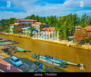 Le paysage du village touristique avec vue sur canal, pleine de kayaks, barques amarrées le long des berges ou flottant au lac Inle, Nyaungshwe, Myanmar. Banque D'Images