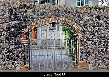 Portes en fer forgé avec leur design. Le fer forgé est utilisé surtout pour la décoration comme dans ces portes doubles dans un vieux mur de pierre Devon. Banque D'Images