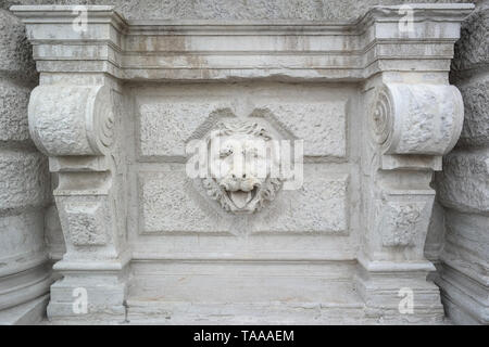 Relief sculpté d'une tête de lion en pierre sur une façade érodée, détail architectural, Venise, Italie, travail classique en pierre Banque D'Images