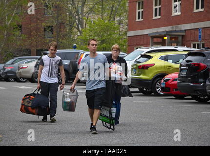 Storrs, CT / USA - 10 mai 2019 : un étudiant se déplace hors des dortoirs accompagné de son frère et de la mère Banque D'Images