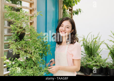 Jolie femme l'élagage des arbres avec des sécateurs dans le jardin Banque D'Images