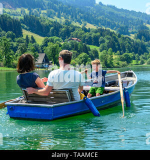 Famille avec chaloupe sur Alpsee Banque D'Images