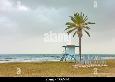 La plage Mackenzie avec palmier et tour de garde de la vie, Larnaca, Chypre Banque D'Images