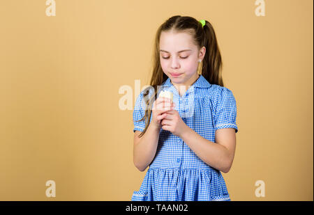 Plus de saveur plus amusant. Petit enfant de lécher la crème glacée à saveur naturelle. Cute little girl apprécier la saveur et arôme de desserts congelés. Kid adorable saveur crème dessert manger additif, copiez l'espace. Banque D'Images