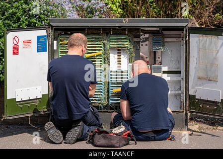 Deux ingénieurs télécoms travaillant dans une boîte de jonction. Telecom, télécommunications junction box ouvert avec l'ingénieur techniciens travaillant Banque D'Images