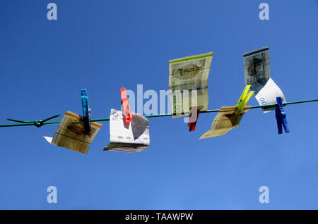 Sonderborg, Danemark - 9 Avril 2019 : Les billets de hanging on a réparé la ligne de lavage, avec un ciel bleu en toile de fond, ce qui suggère que l'argent blanchir a ta Banque D'Images
