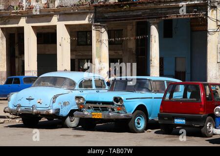 La HAVANE, CUBA - 30 janvier 2011 : Les gens se tiennent près des voitures stationnées à La Havane, Cuba. Cuba a l'un des taux de location par habitant élevés (38 pour 1000 personnes Banque D'Images