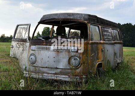 1976 Volkswagen Bus abandonnés assis dans un champ. Banque D'Images