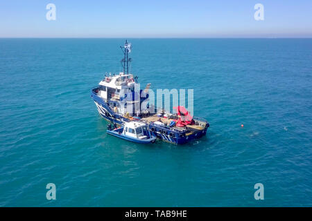 Bateau de pêche en mer avec un plus petit bateau amarré à côté - Vue aérienne de l'image. Banque D'Images