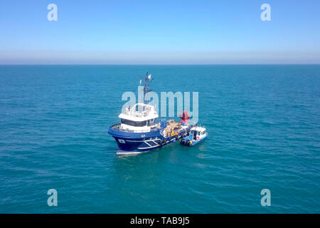 Bateau de pêche en mer avec un plus petit bateau amarré à côté - Vue aérienne de l'image. Banque D'Images